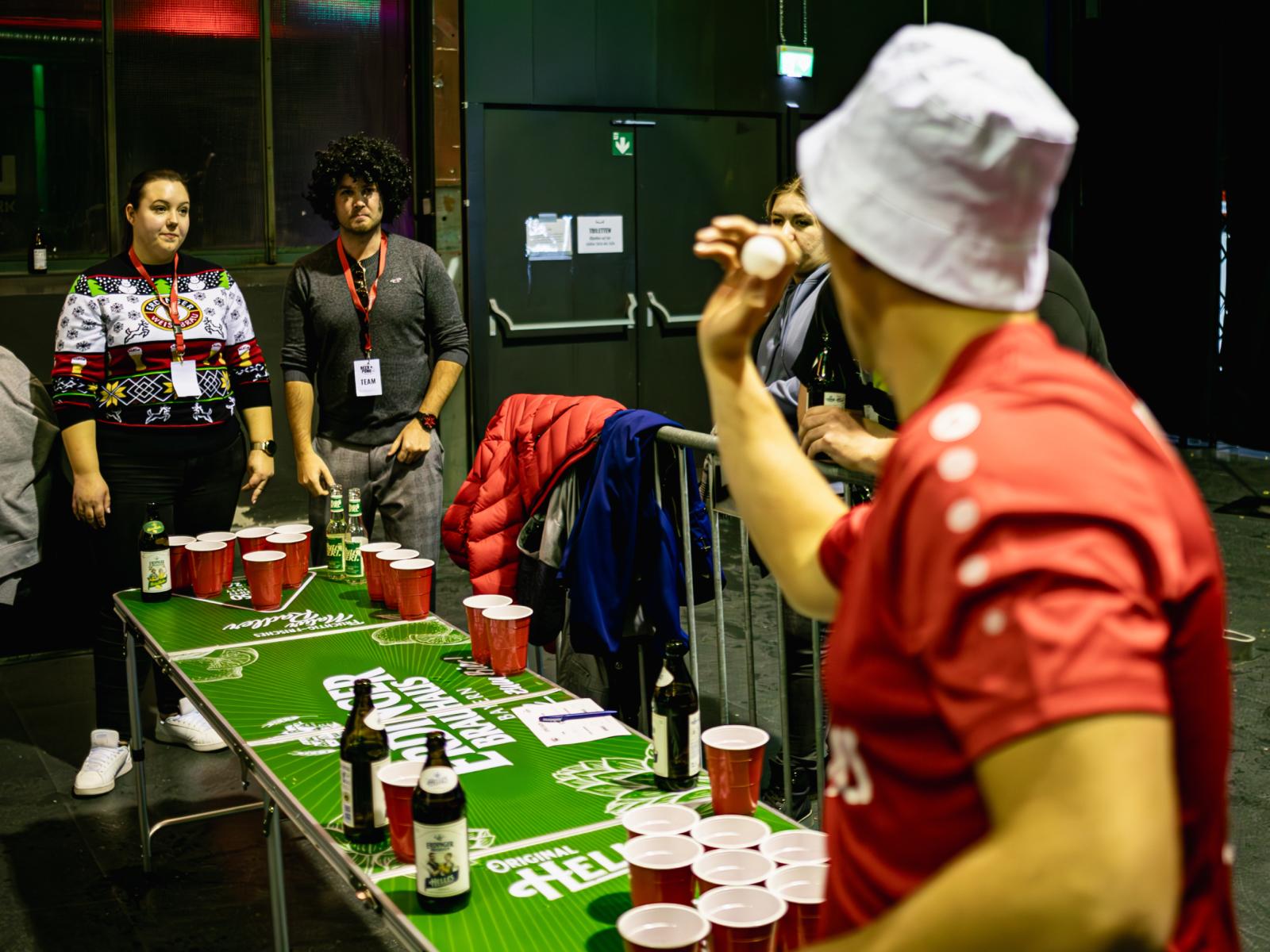 Zwei Personen spielen gegeneinander Beerpong auf einem ERDINGER Brauhaus Bierpongtisch.