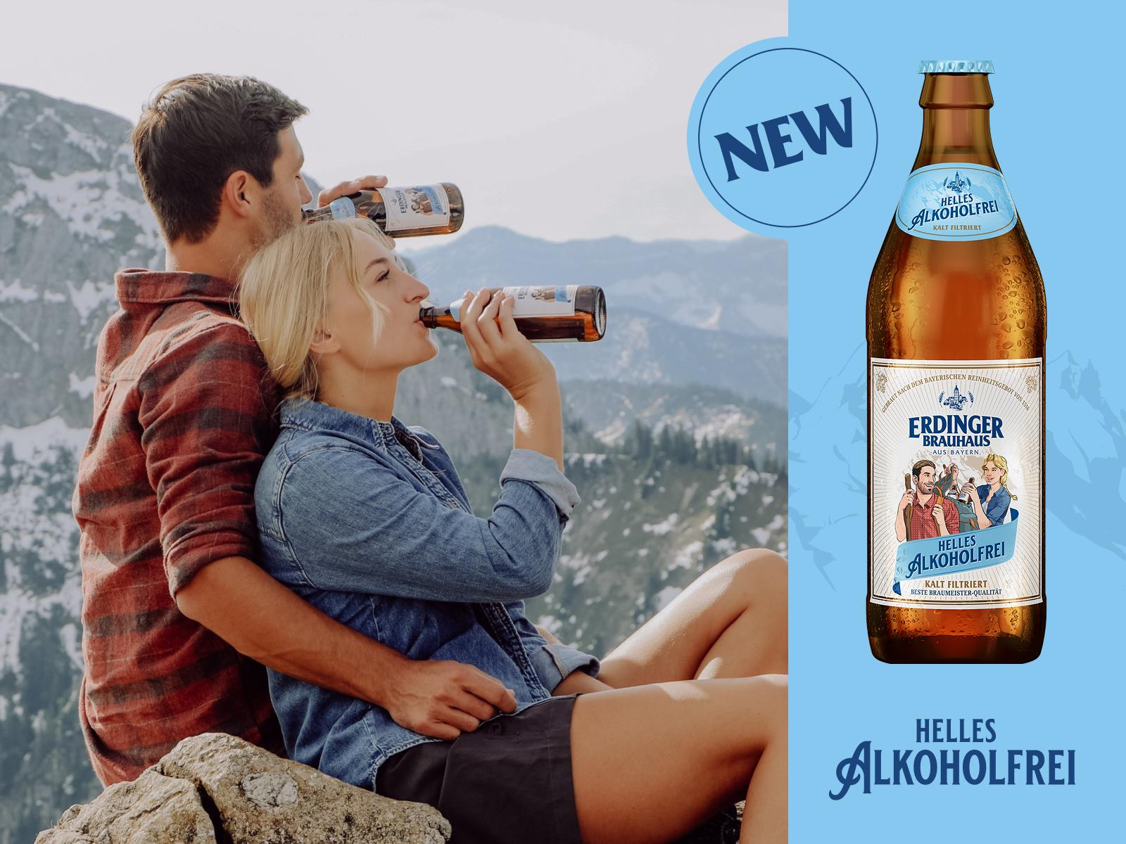 A couple looks down together from a mountain peak into the valley while drinking ERDINGER Helles Alkoholfrei.