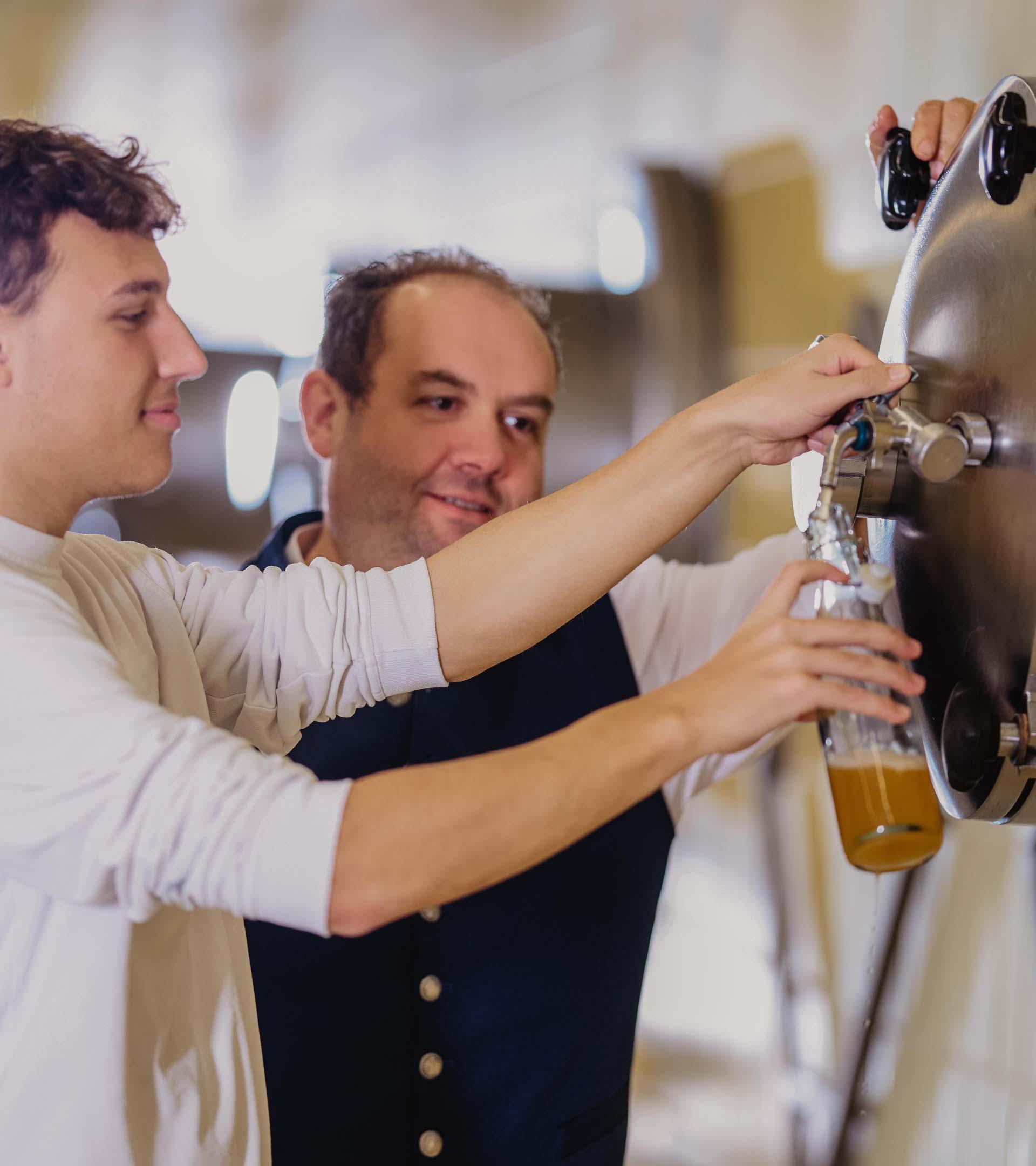 ERDINGER Industriemechaniker zeigt Kollegen ein Ersatzteil.