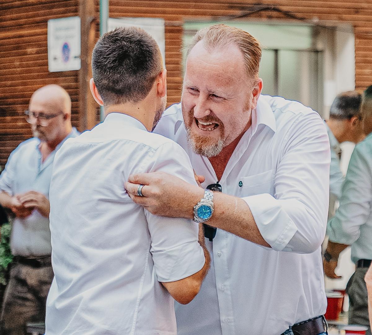 Two colleagues from ERDINGER are giving each other a friendly hug.