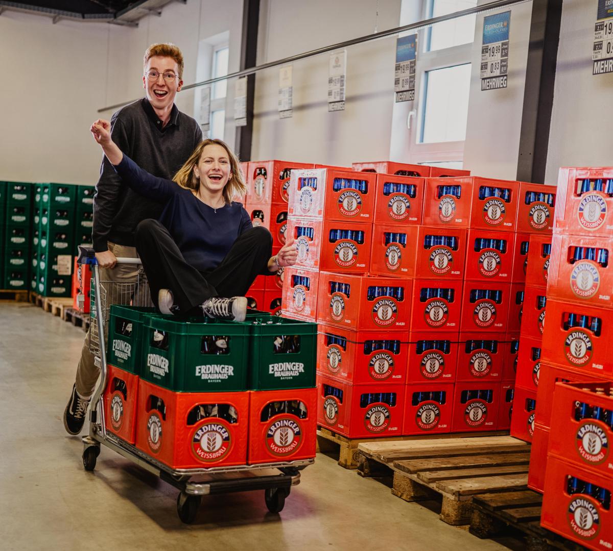 Happy trainees with a shopping cart and beer crates at the ERDINGER in-house distribution.