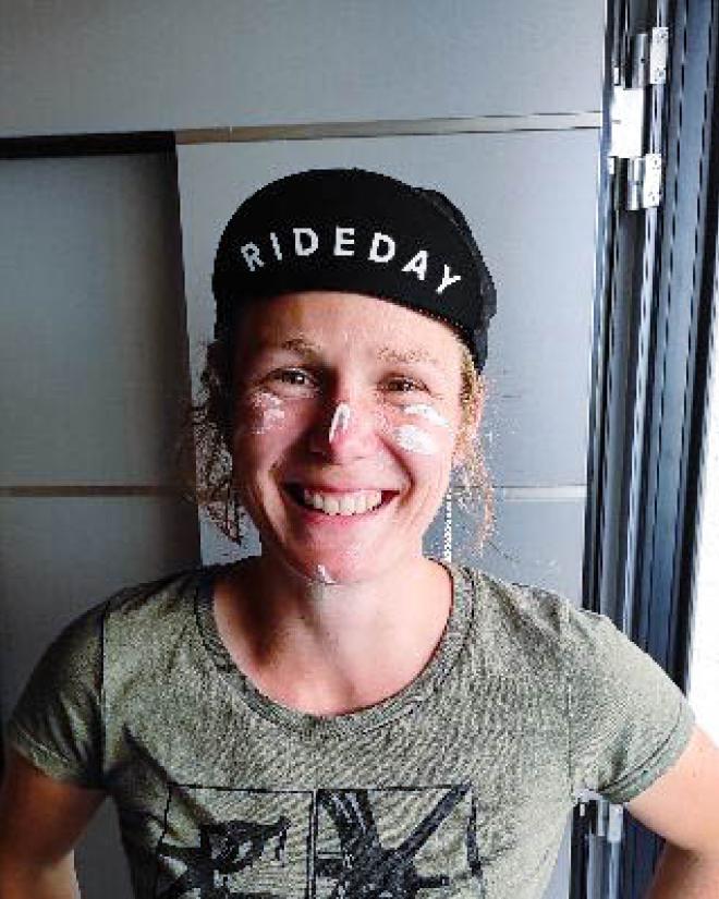A smiling woman with un smeared sunscreen on her face.