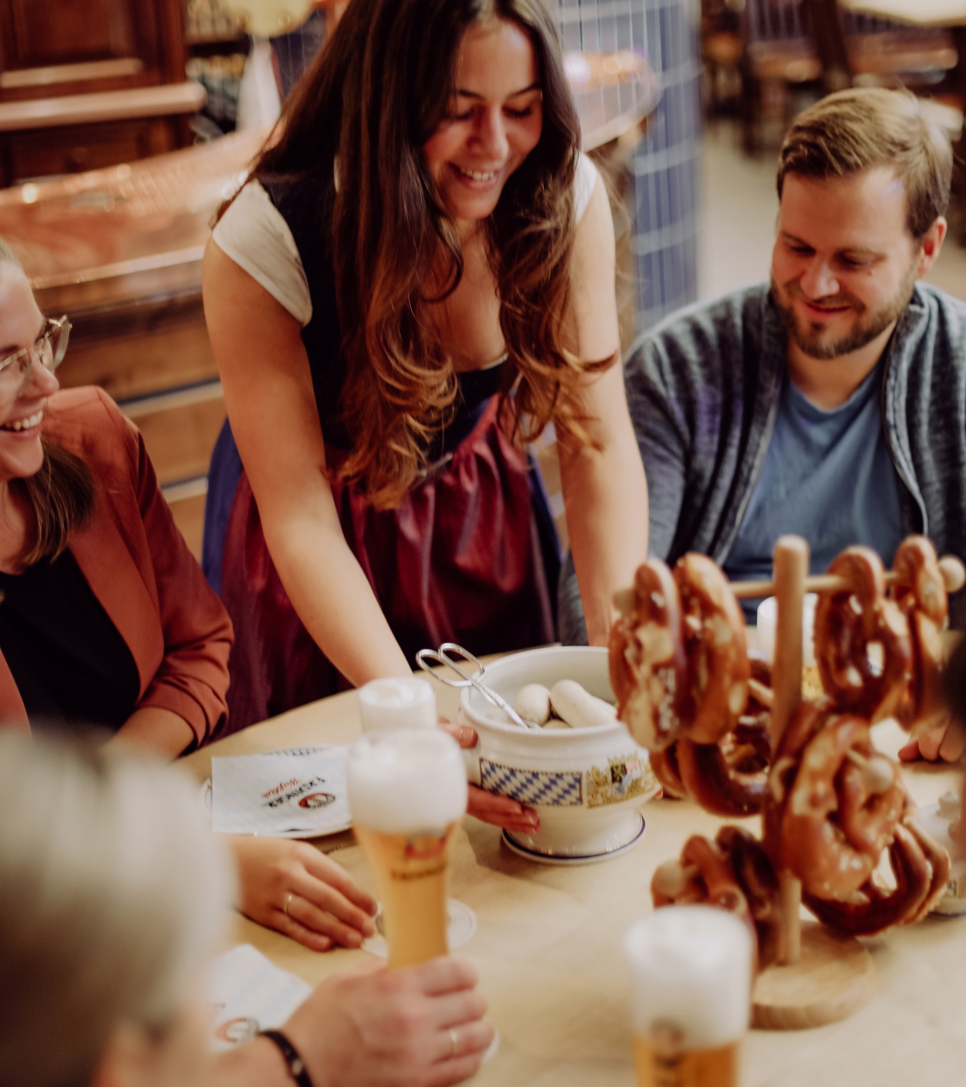 Michael Sobolewski stands in front of glasses with various raw materials and explains them during the ERDINGER brewery tour.