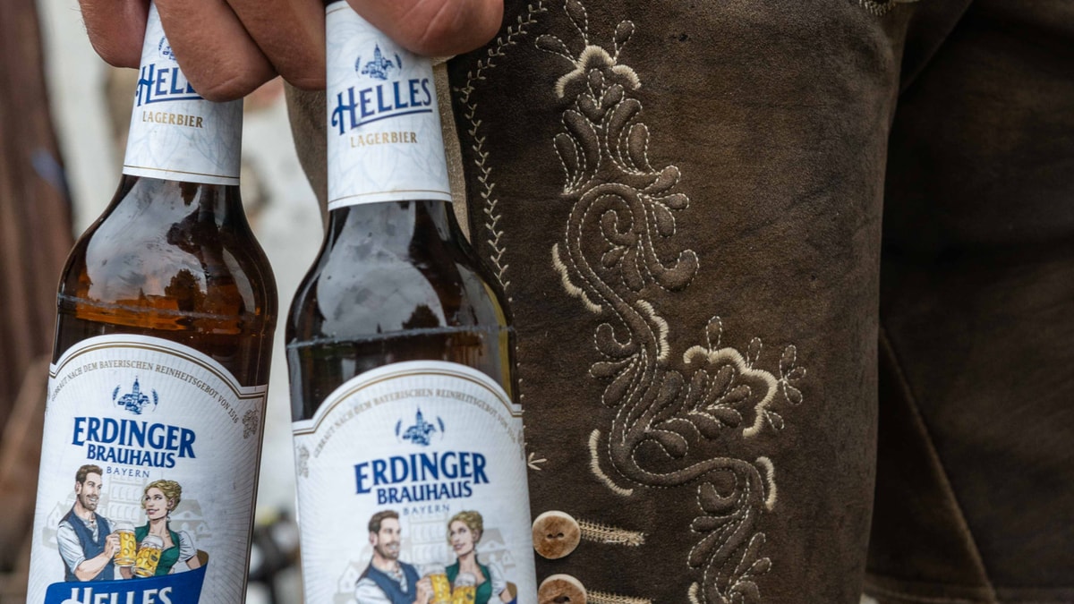 Close-up of two ERDINGER Brauhaus Hell bottles in front of a leather trousers.