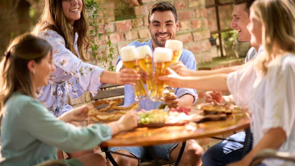 A sociable group raises their glasses with ERDINGER wheat beer.