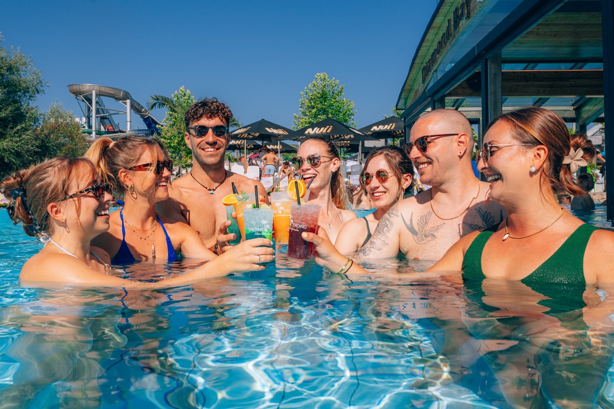 Mehrere Freunde stoßen in der THERME ERDINGER an.