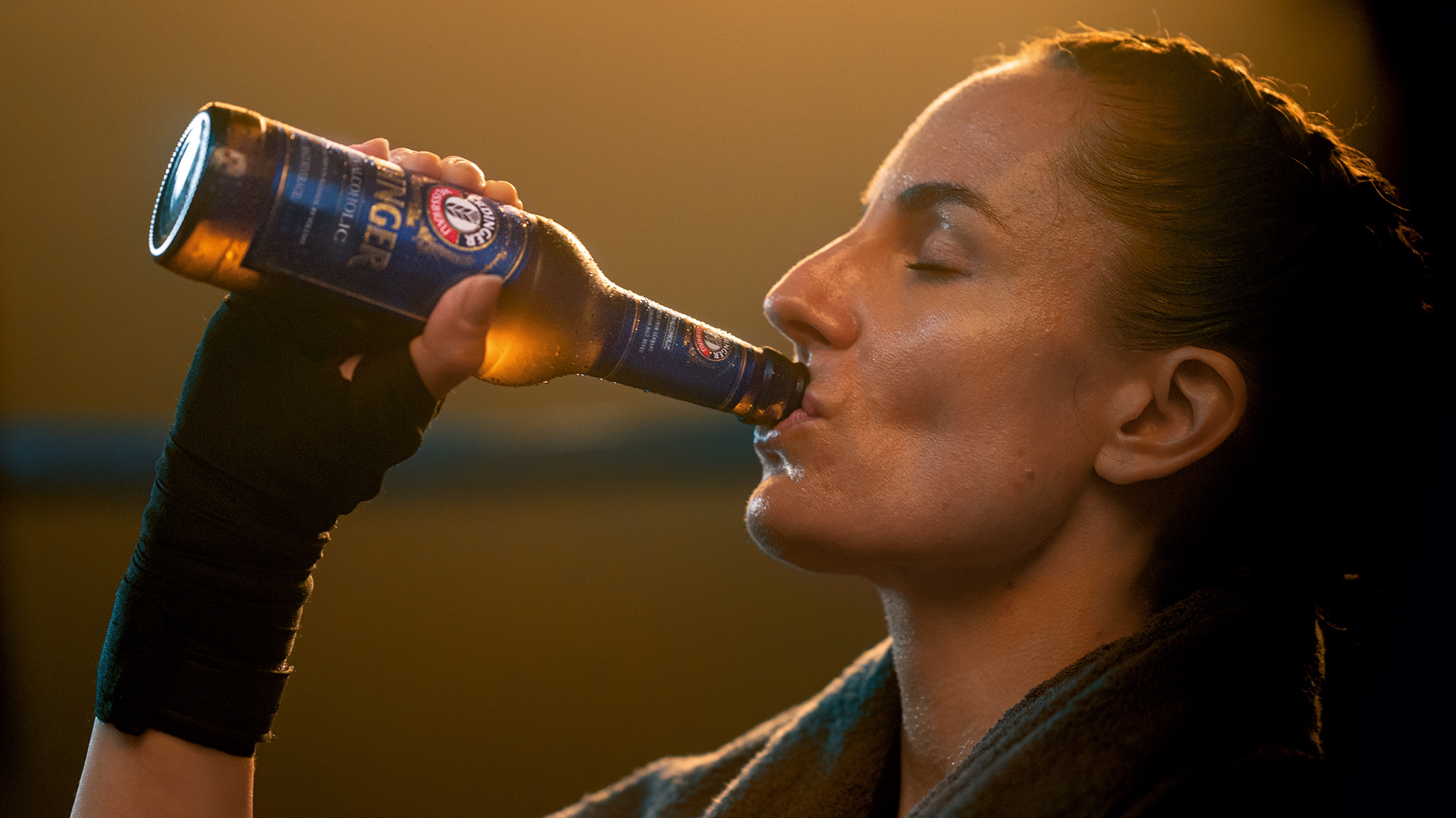 A female boxer enjoys drinking an ERDINGER Non-Alcoholic after her training.