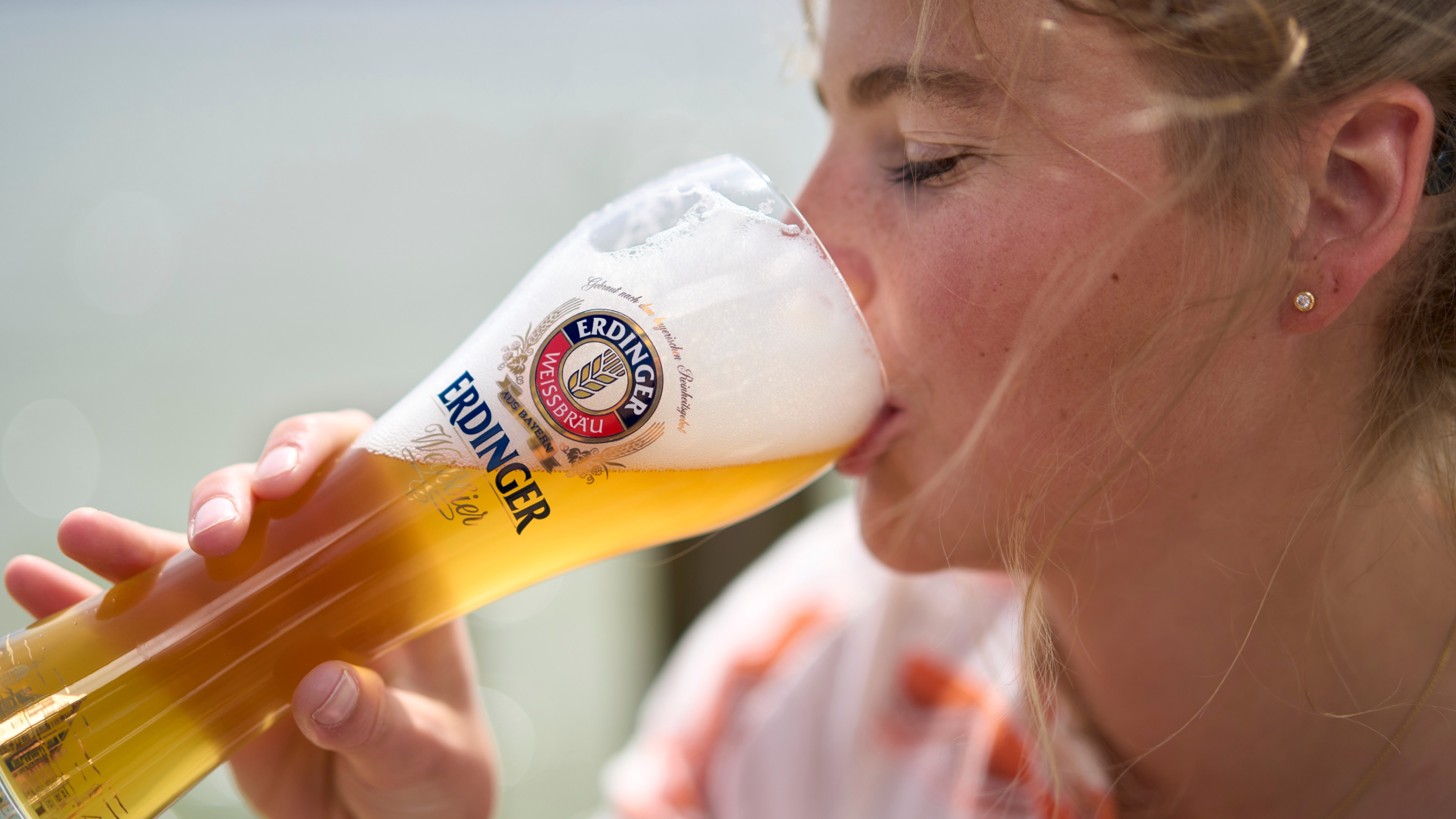 Jürgen Klopp smiling with a glass of ERDINGER Weißbier.