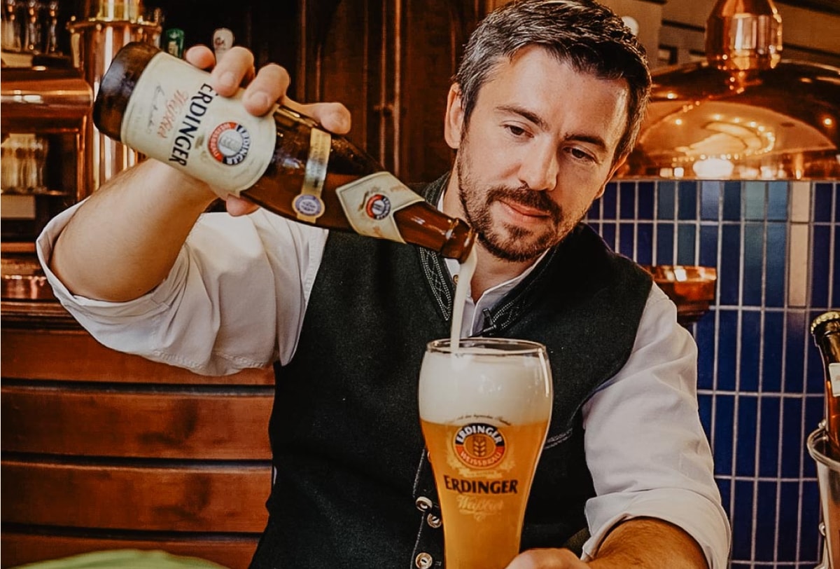 A bartender examines the foam crown of the ERDINGER wheat beer.