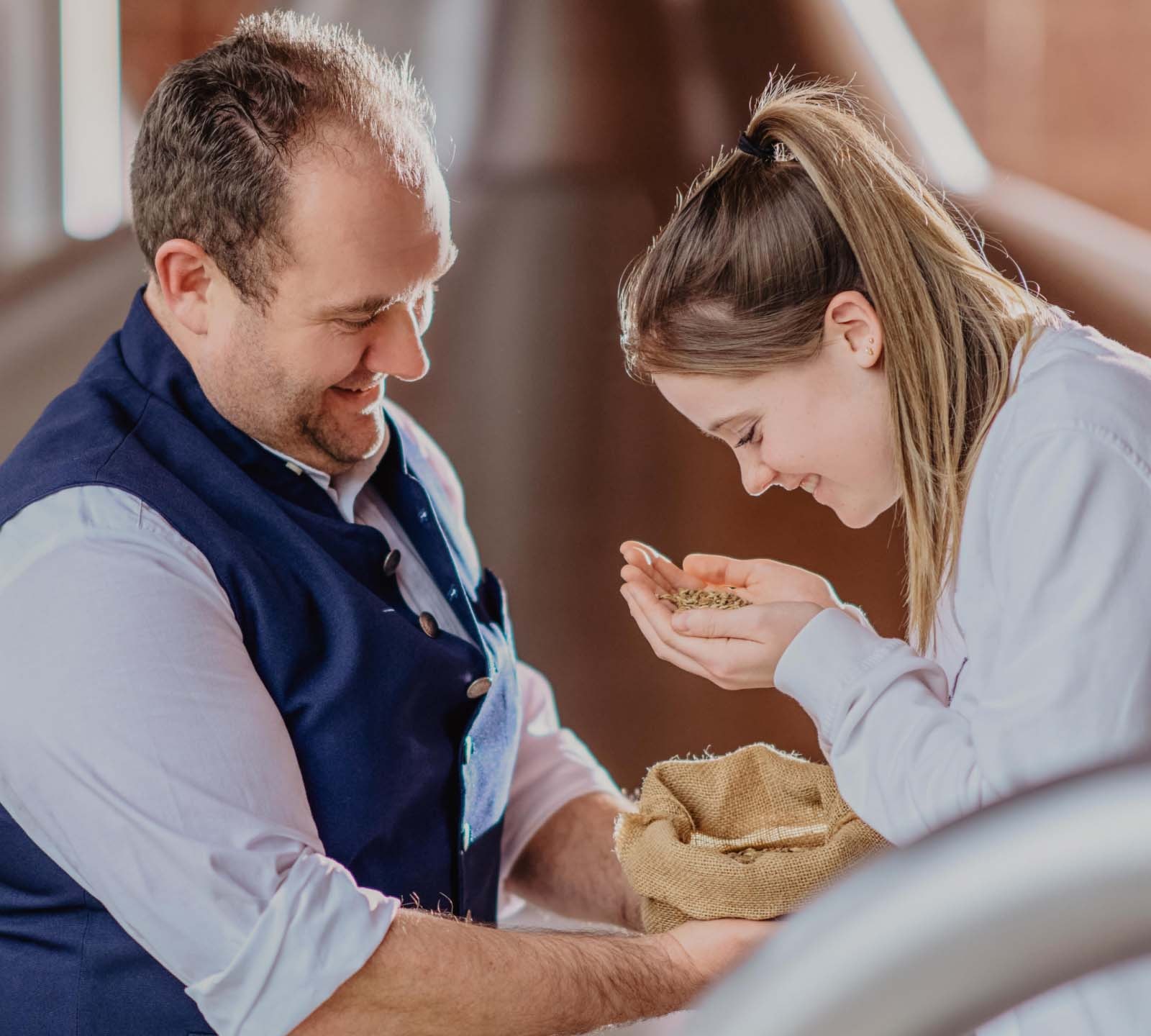 ERDINGER Brauer begutachtet mit Auszubildender Malzkörner.