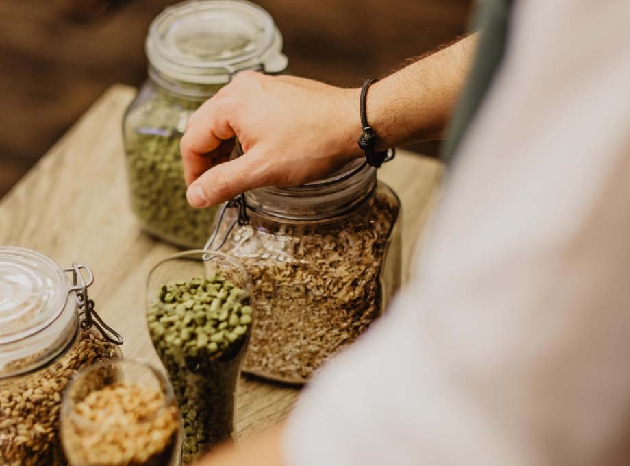 Nahaufnahme von Rohstoffen zur Bierherstellung bei ERDINGER in Gläsern.