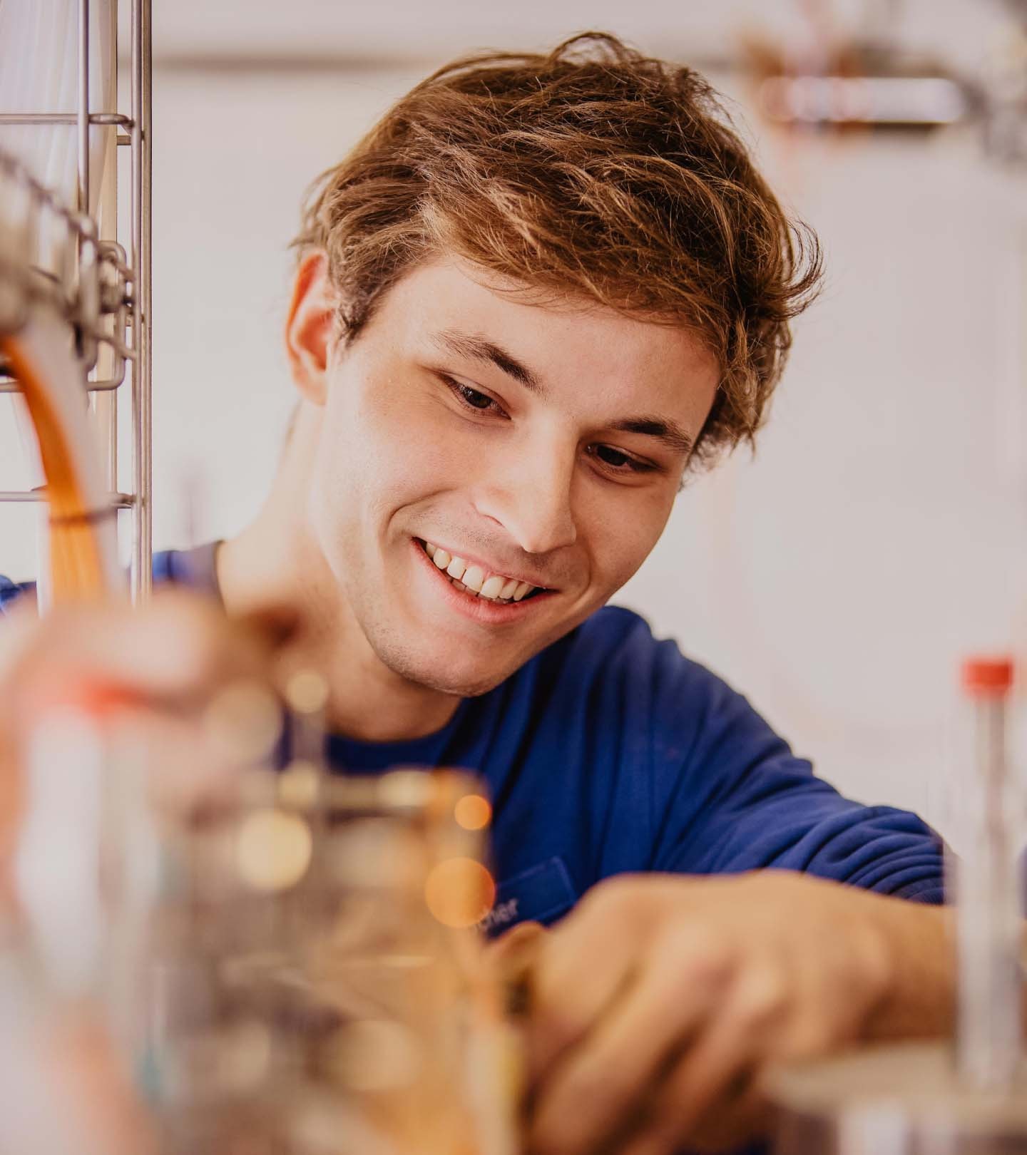 Junger ERDINGER Elektroniker arbeitet an Kabeln.