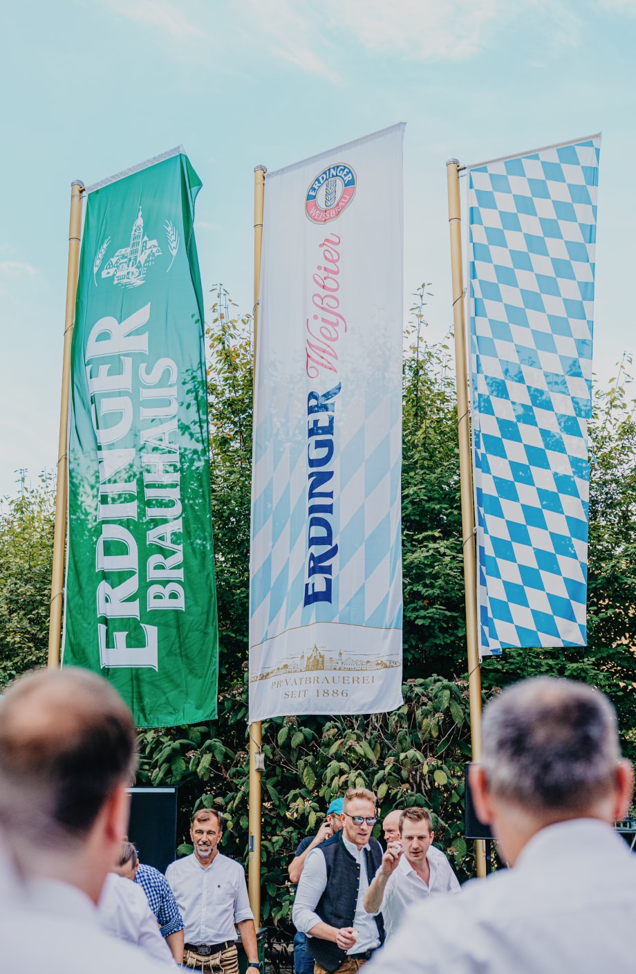 ERDINGER Fahnen wehen im Hintergrund bei Firmenevent.