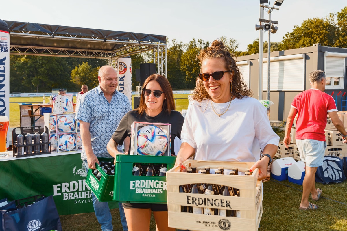 Sieger und Siegerinnen holen gewonnene ERDINGER Bierkästen ab.