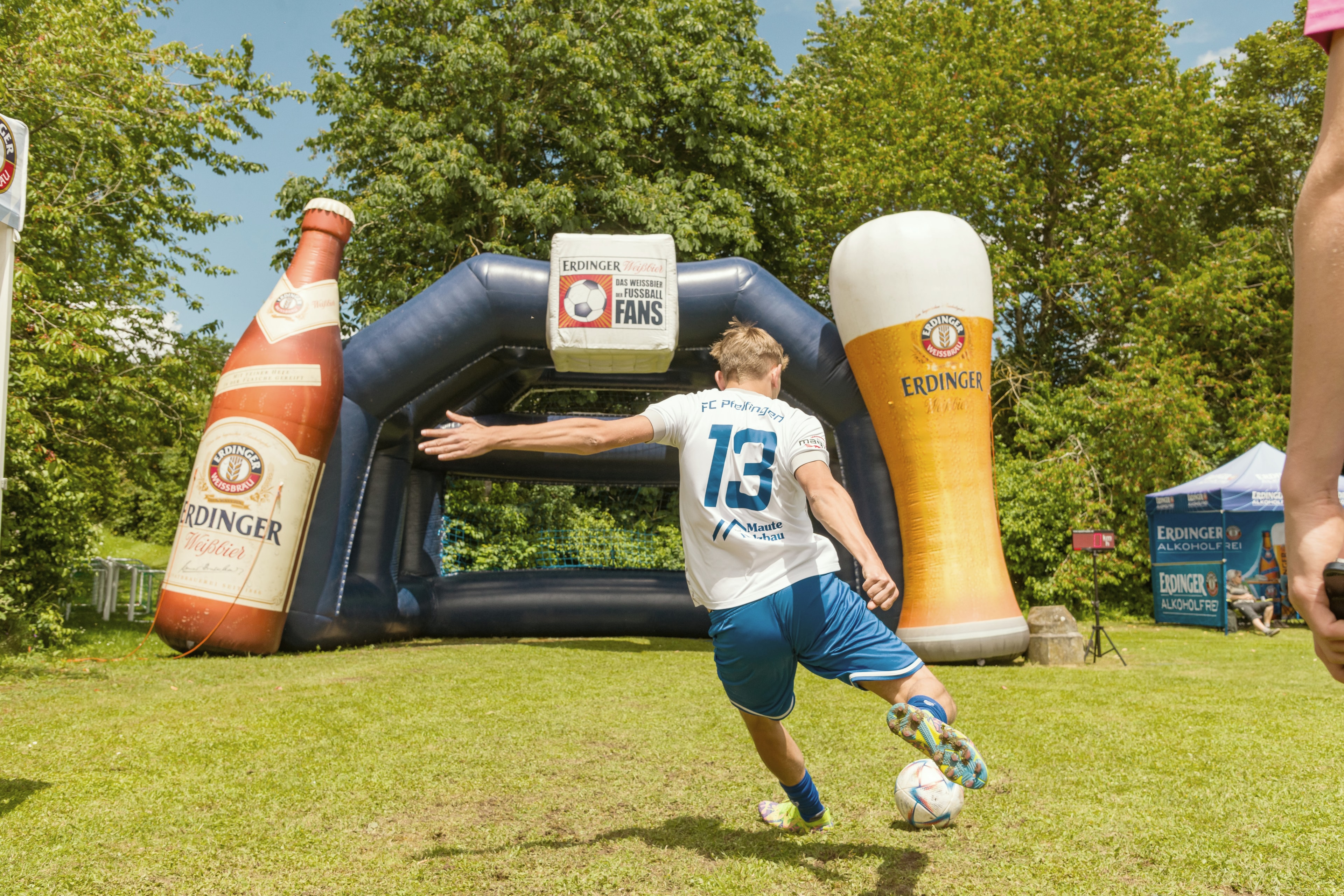 Ein Spieler schießt auf ein aufblasbares Tor welches eine ERDINGER Flasche und ein gefülltes ERDINGER Glas als Torpfosten darstellt.