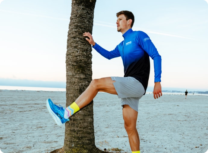 Triathlete warming up before running training on the beach of Palma de Mallorca.