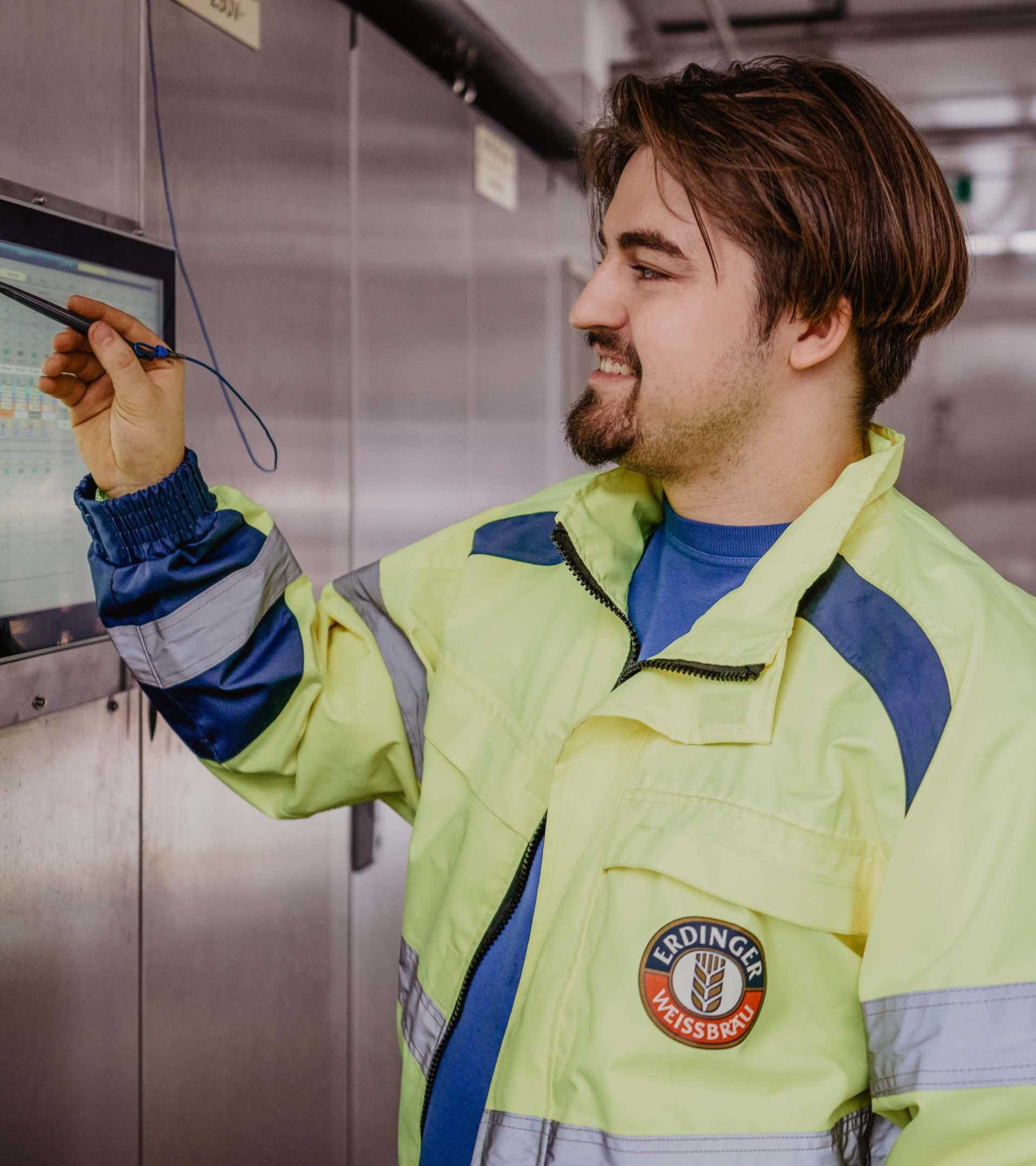 ERDINGER Elektroniker nimmt Einstellungen an einem Touchscreen vor.
