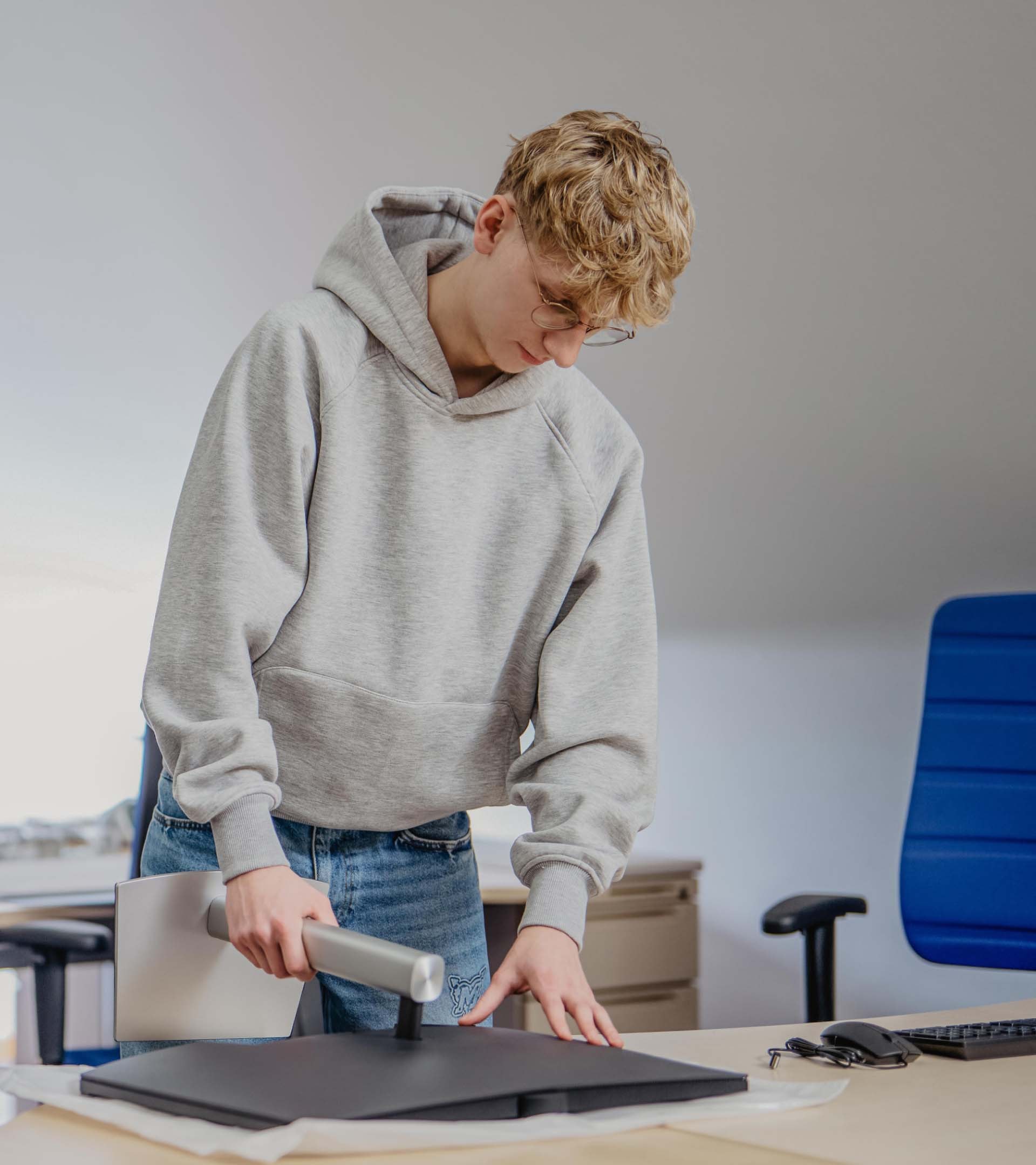 ERDINGER Fachinformatiker steht vor zusammengebautem Monitor.